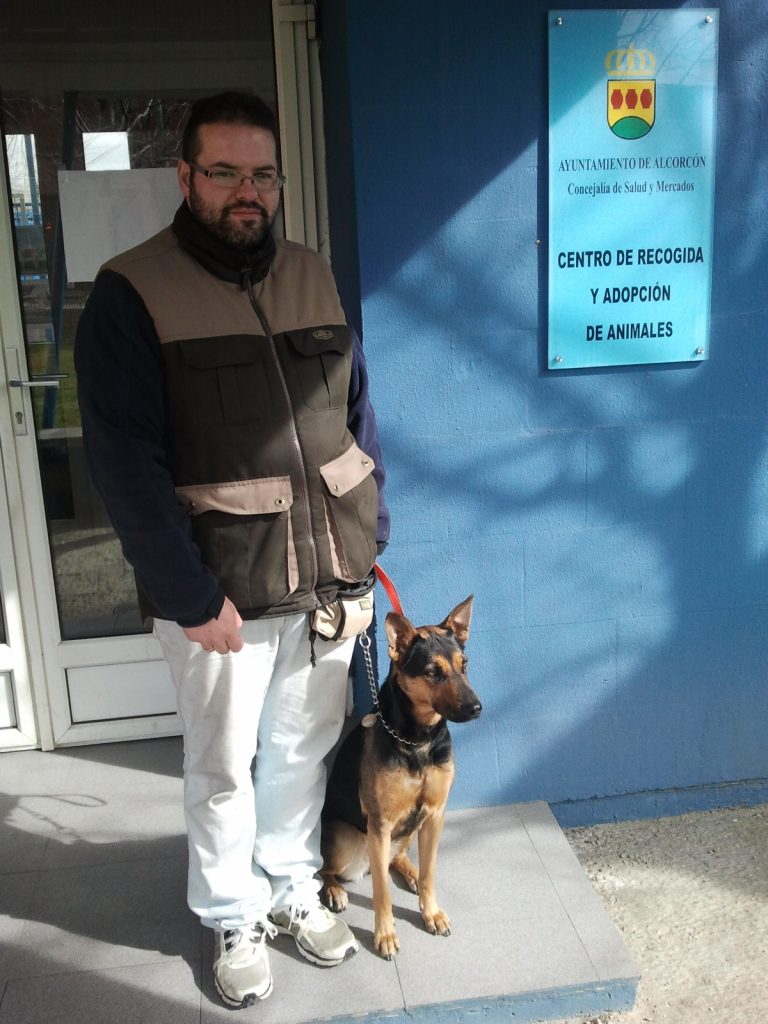 Hombre sostiene la correa de un perro junto a la entrada del Centro de Recogida y Adopción de Animales de Alcorcón.